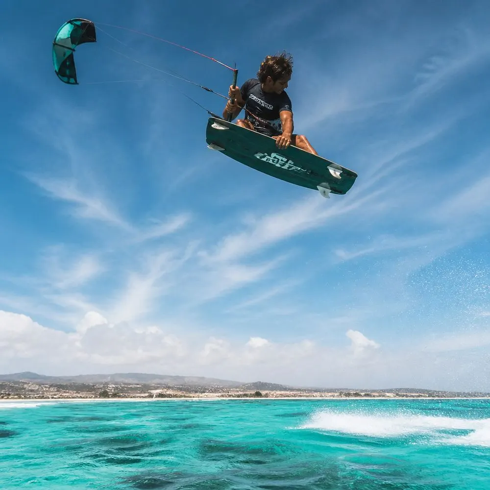 Kitesurfista saltando sobre el mar turquesa en Kite Beach, Isla de Sal