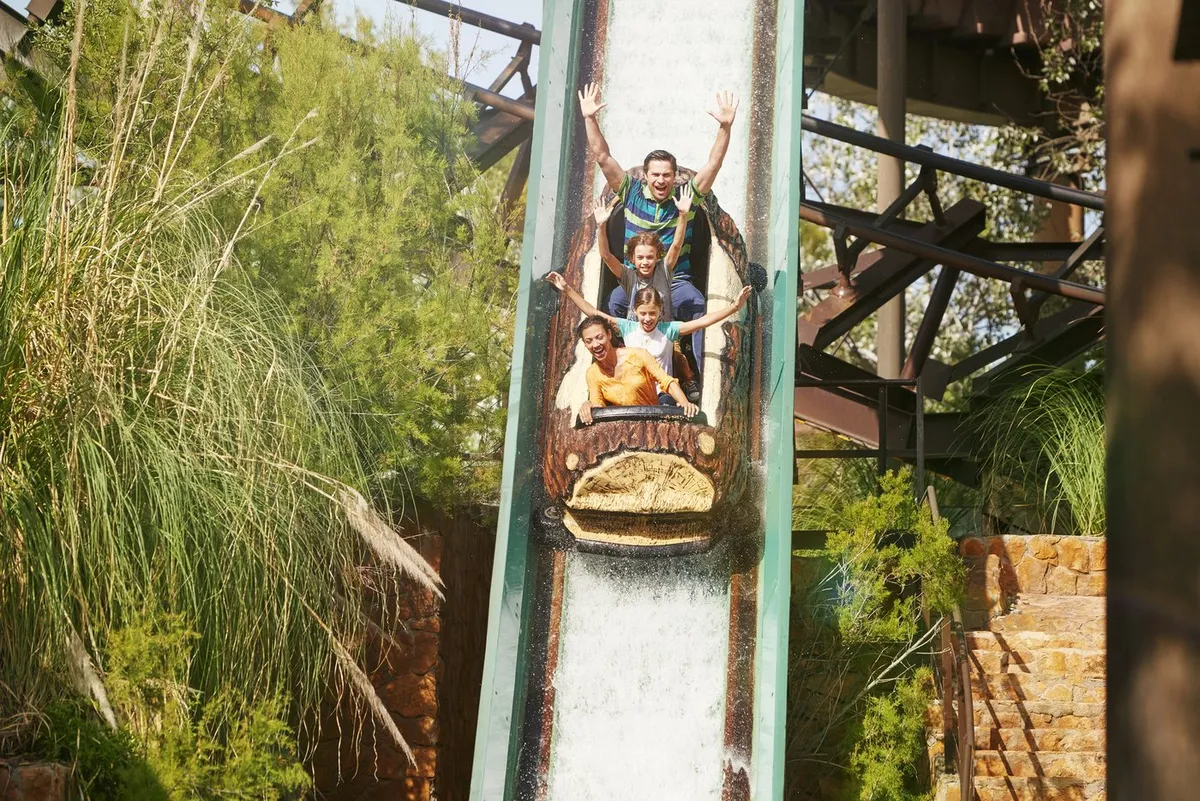 Tronco de Silver River Flume cayendo por la rampa final con una familia a bordo