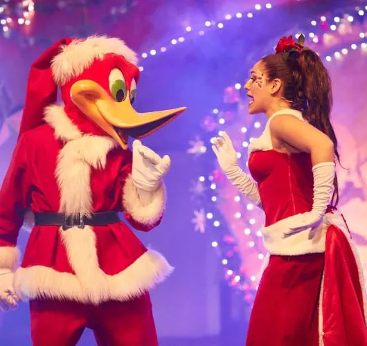 Woody vestido de Papá Noel con una bailarina en el escenario